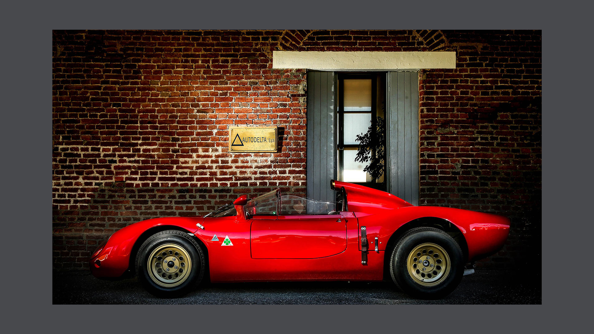 Photo of a vintage car outside the entrance to the Autodelta