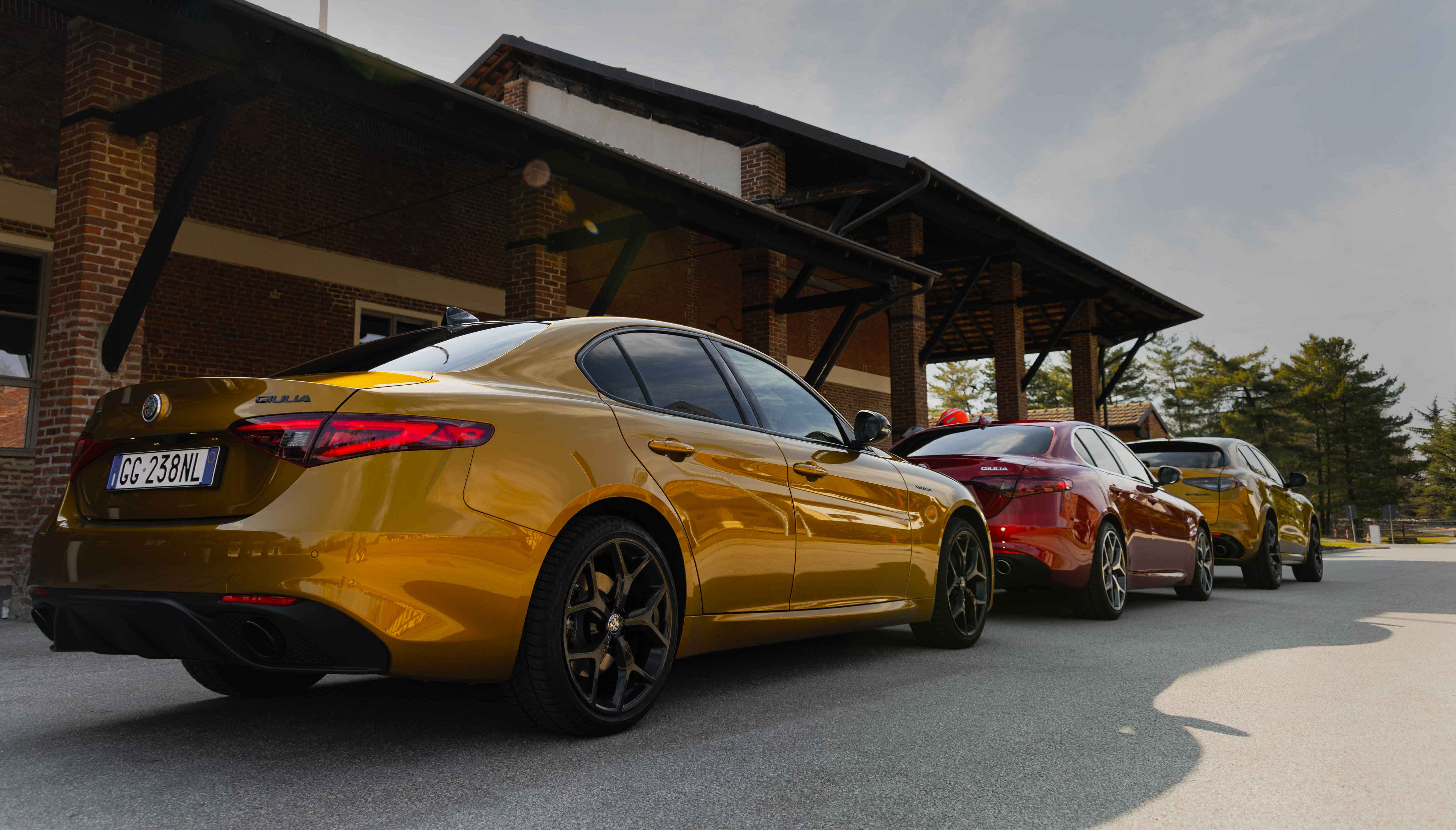 Photo of three Alfa Romeo cars parked in front of Autodelta