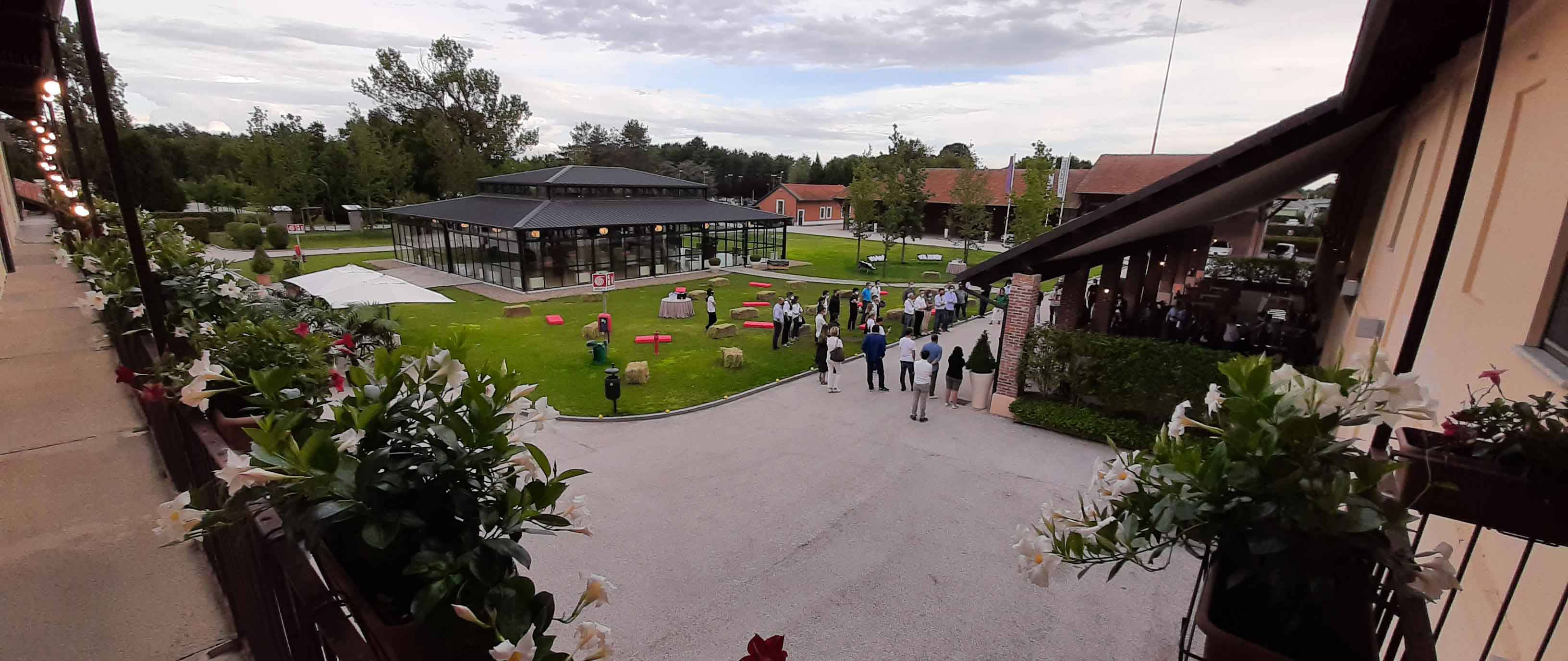 Photo of an event in the courtyard where we catch a glimpse of both the furnished porch and the Exterior Pavilion