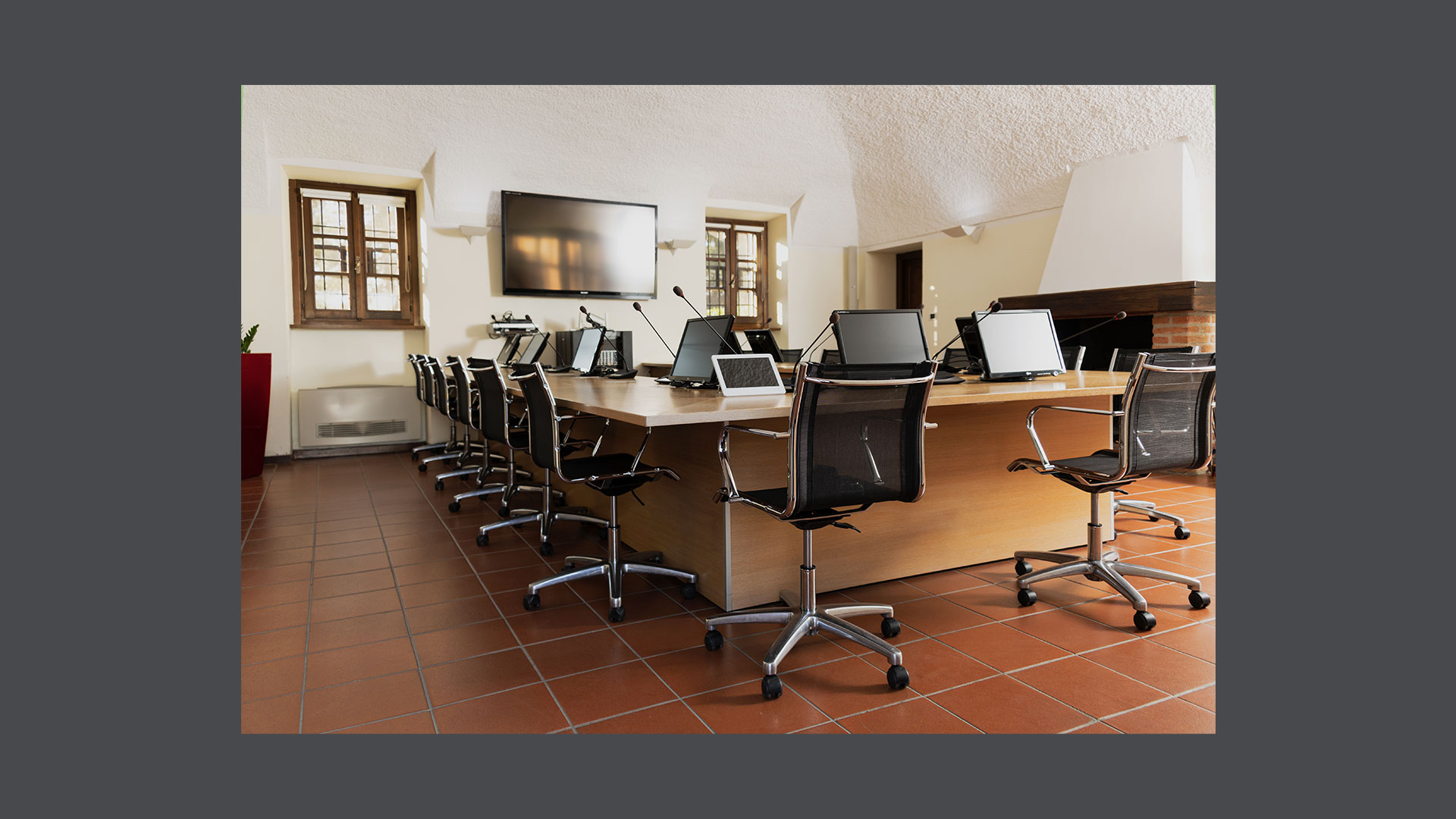 Photos of the Rappresentanza Room consisting of a large horseshoe table capable of seating 20 people and a modern audio-video system with a large central screen