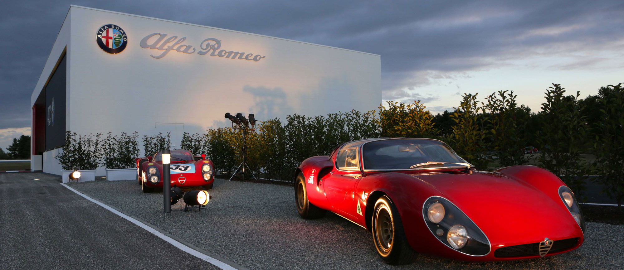 Photos of vintage Alfa Romeo cars parked in front of the Grandstand