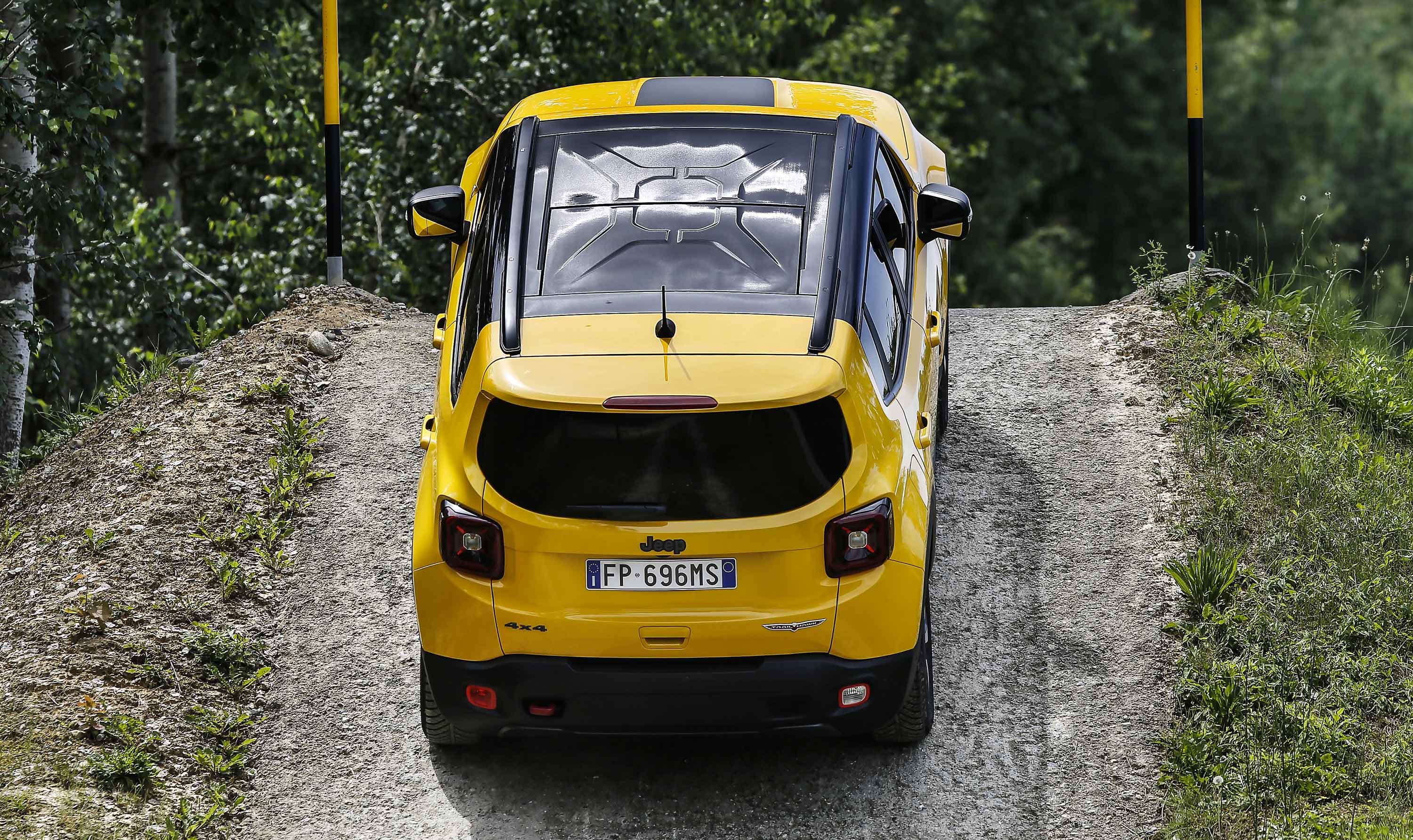 Photo of a yellow Jeep tackling an uphill dirt road