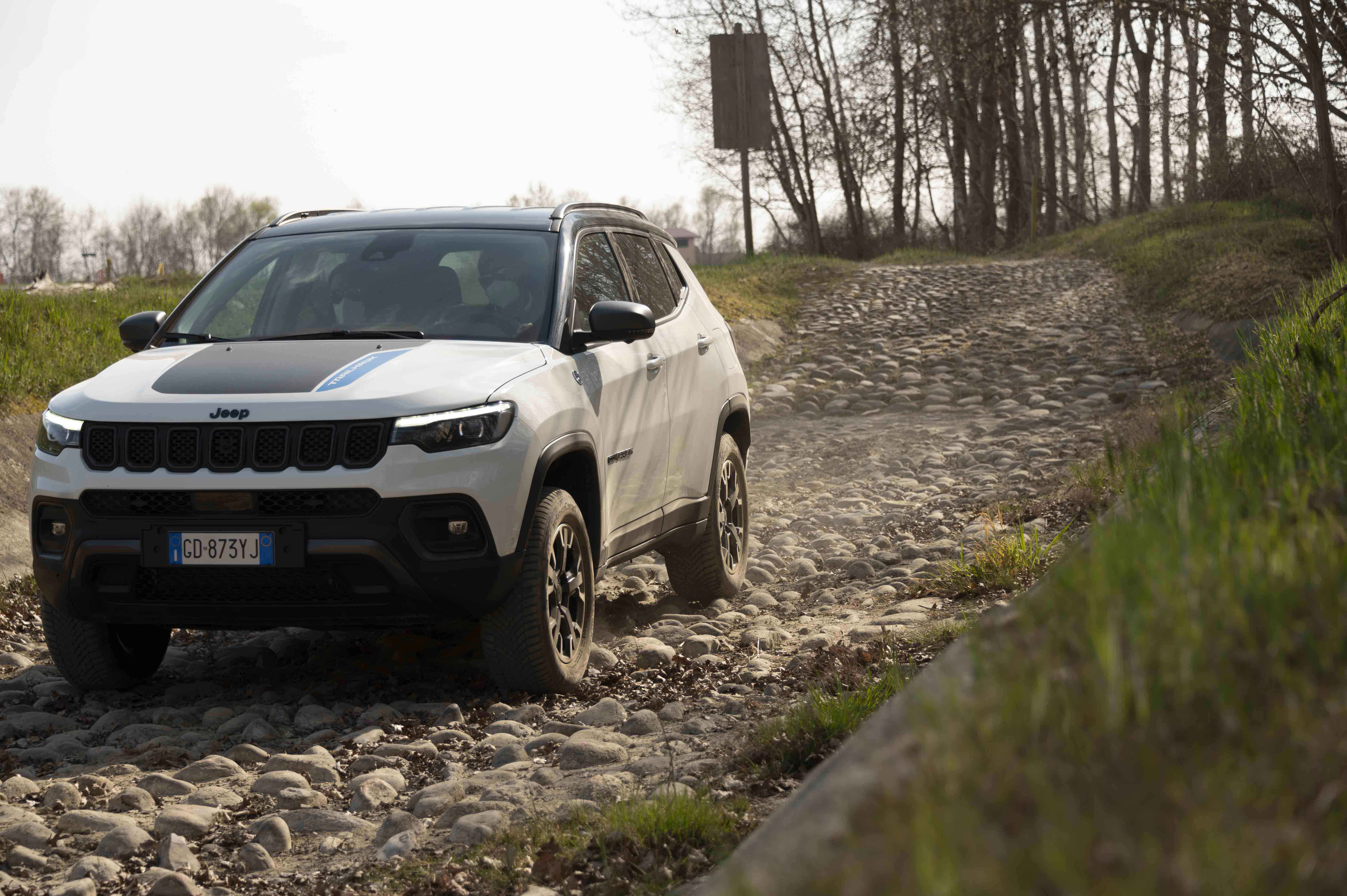 Photo of a white Jeep crossing a segment of the track with cobblestones