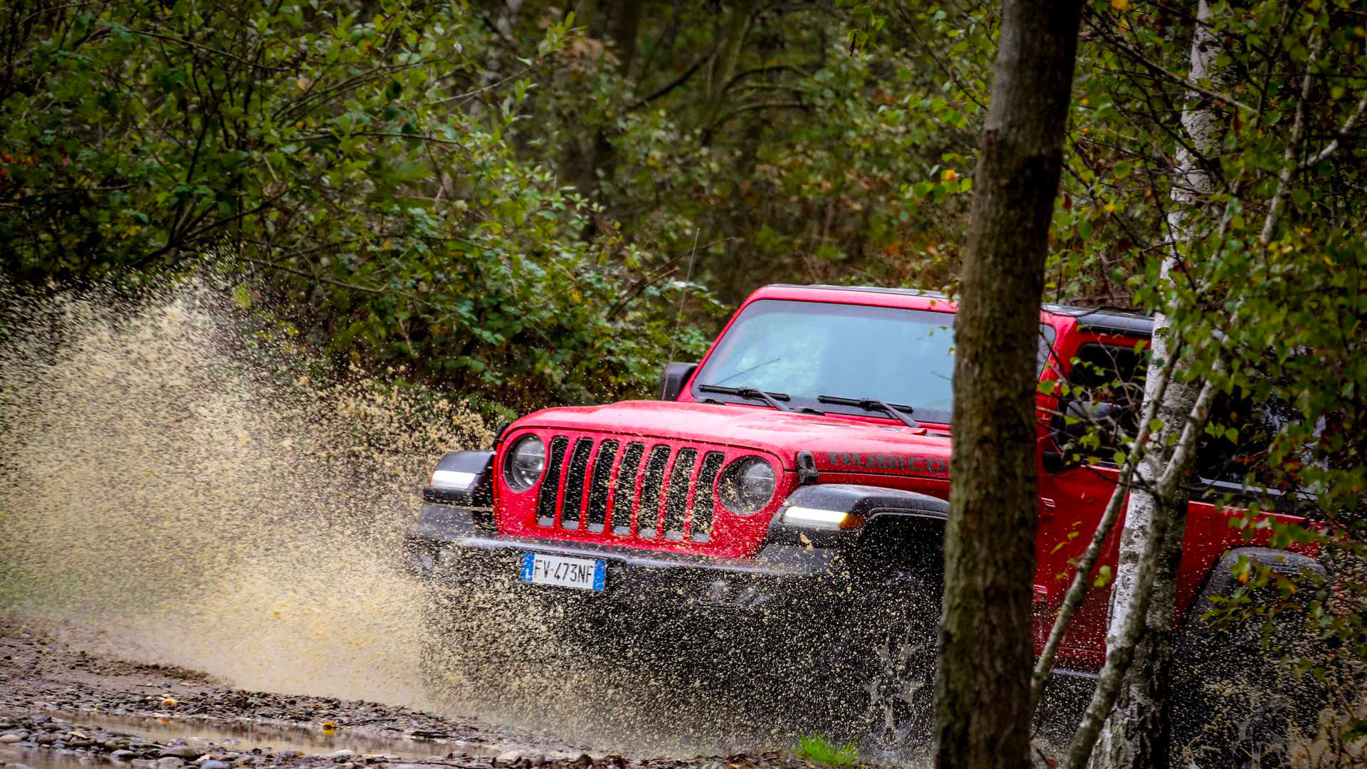 Photo of a red Jeep tackling a flooded ford