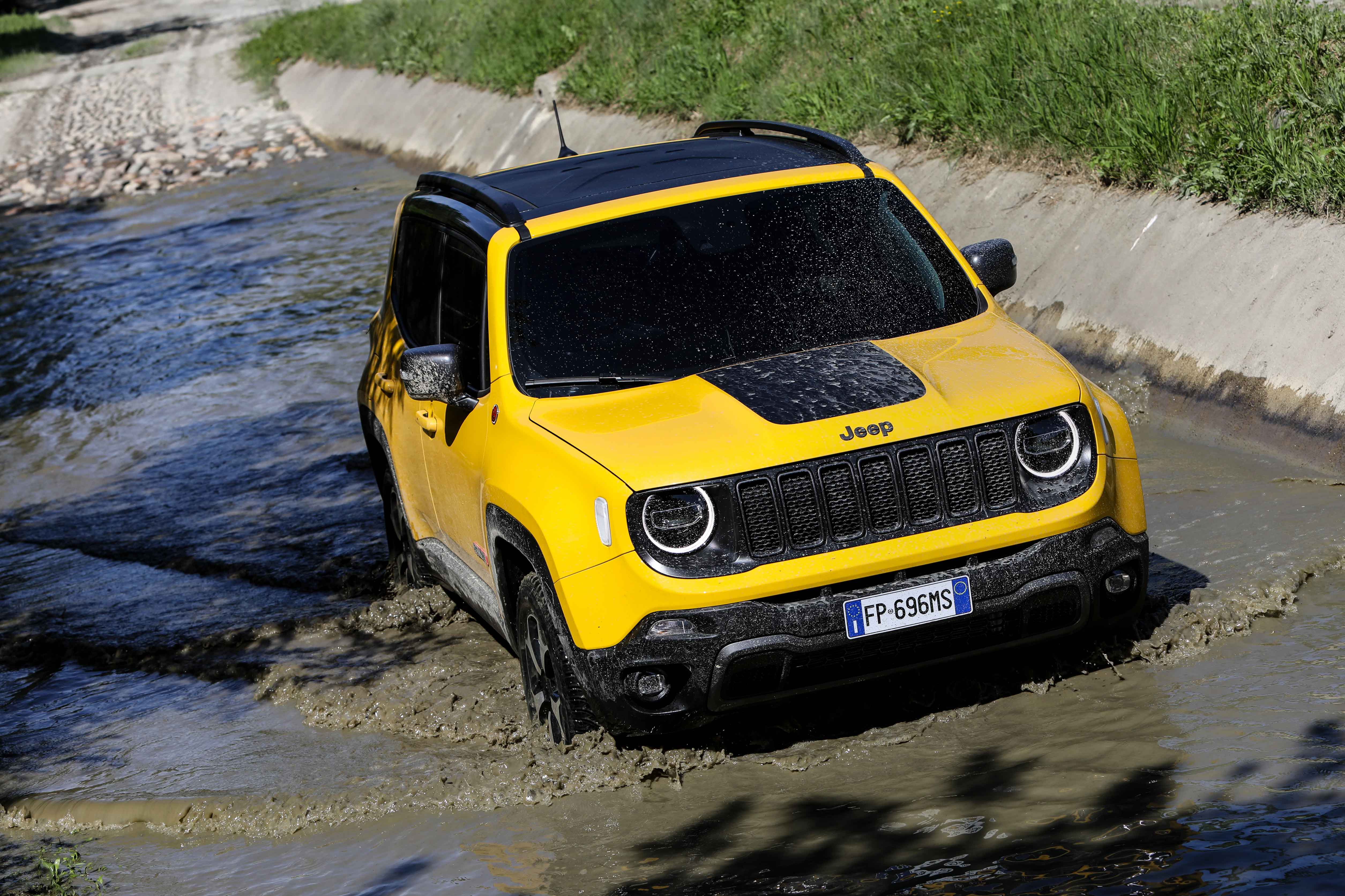 Photo of a yellow Jeep on muddy ground